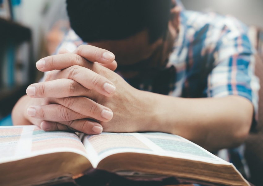 man-praying-hands-clasped-together-on-his-bible_t20_4lWneR